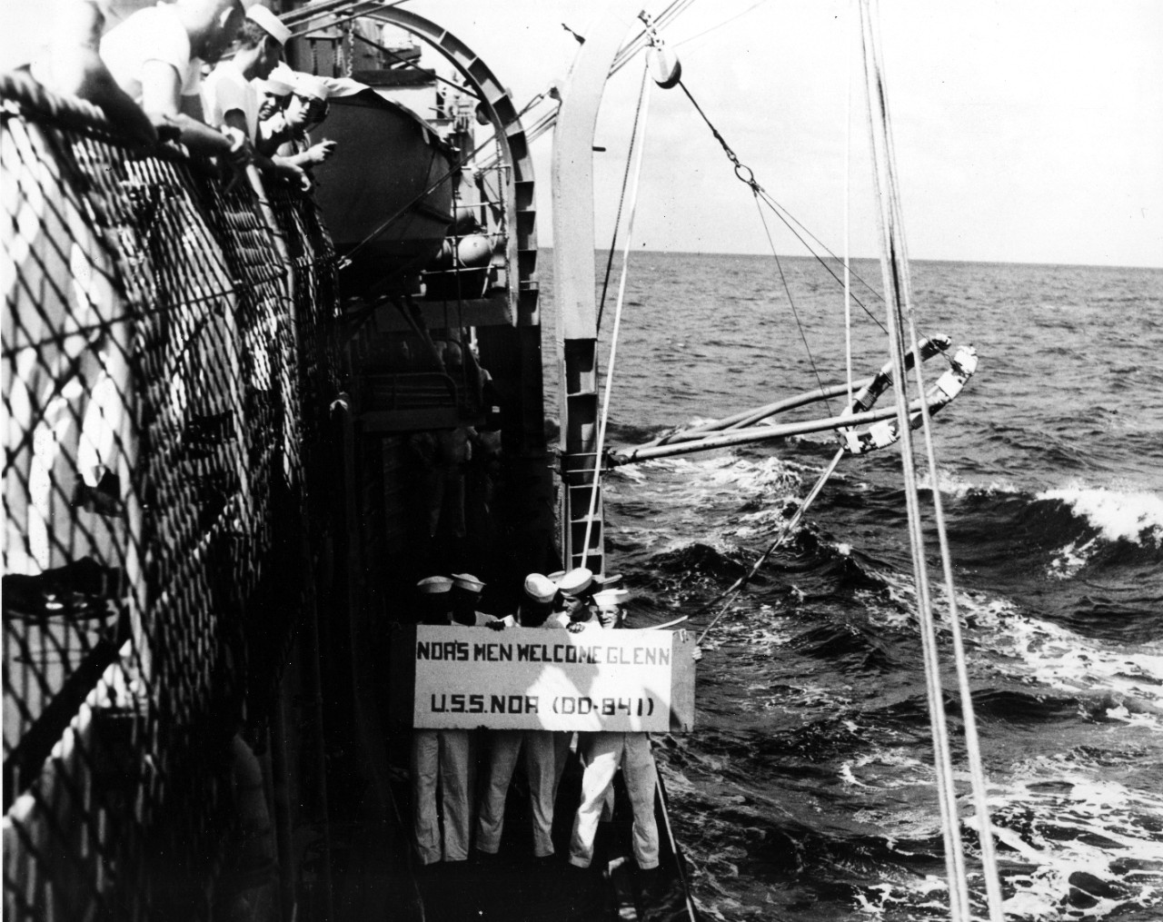 Cape Canaveral, FL - naval personnel of USS Noa (DD-481) line ship's rail holding welcoming sign to astronaut John H. Glenn, as they participate in recovery of spacecraft after world orbital flight. February 20, 1962. 