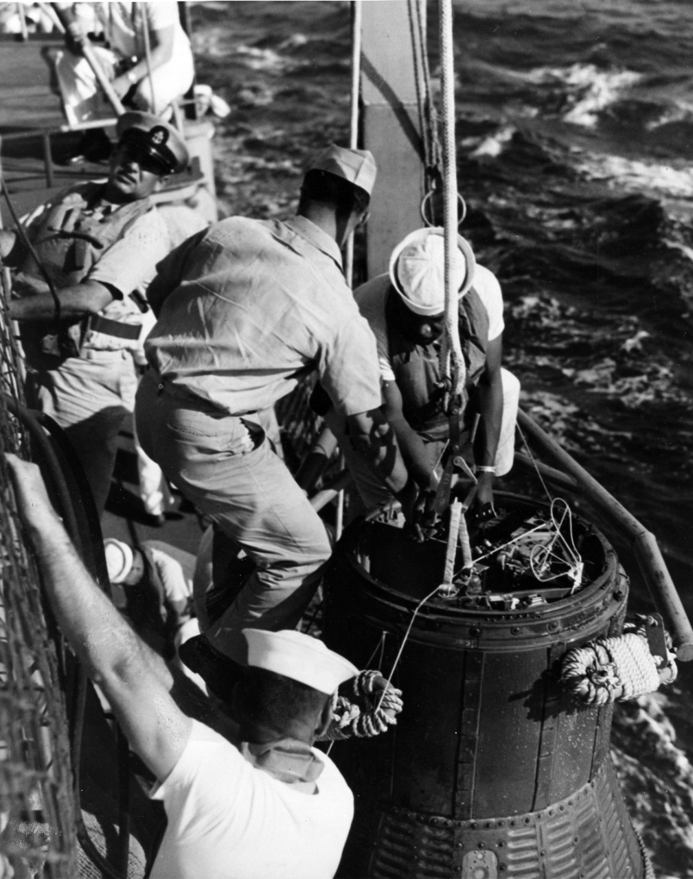 Cape Canaveral, FL - naval personnel of USS Noa (DD-841) hook on recovery equipment as astronaut John G. Glenn's NASA Friendship 7 spaceship is recovered after world orbital flight. February 20, 1962. 