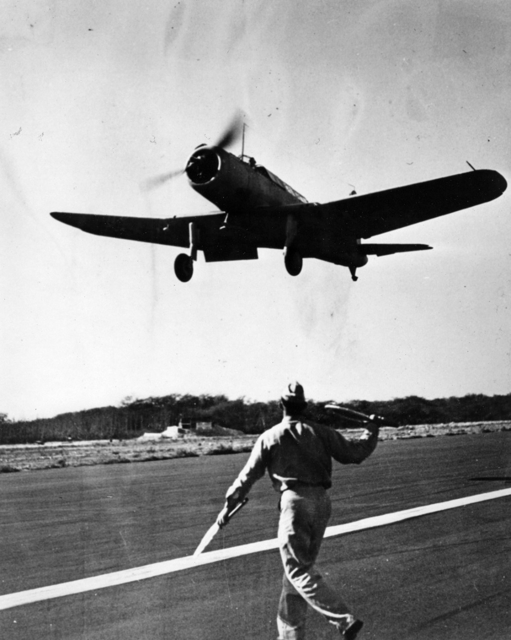 Vought SB2U-3 Vindicator of VMS-2 engaged in a "Bounce Drill" (field carrier landing practice) circa June 1941, at Ewa Field, Hawaii. Group landing signal officer at that time (foreground) was First Lieutenant Robert E. Galer, later awarded a Medal of Honor at Guadalcanal.
