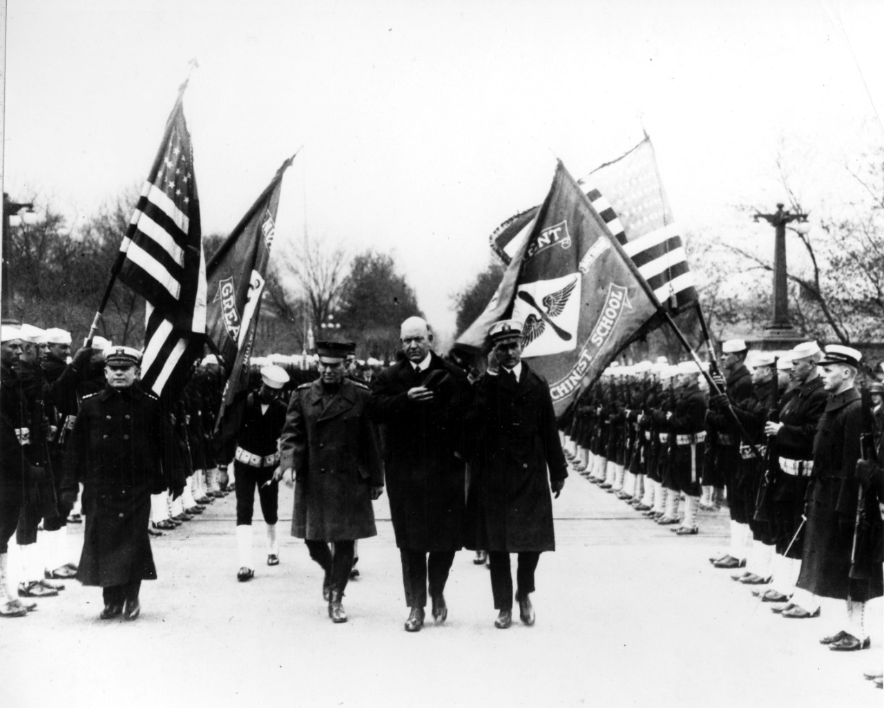 MGen John A. Lejune, SecNav Edwin Denby, and CAPT William A. Moffett inspect sailors at NTC Great lakes, IL during the early 1920s. Note the flag of aviation machinist school at right. 