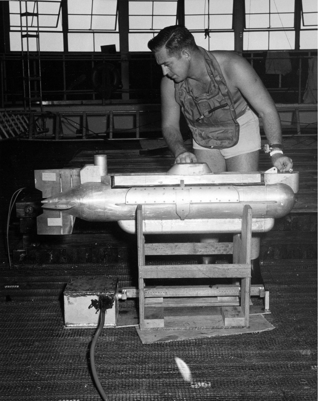 LT G.M. Brewer, USN, head of the Navy Underwater Photographic Team check as a scale model of the proposed deep water oceanographic submarine Aluminaut, during test conducted at the Naval Ordnance Laboratory, White Oaks, MD. June, 1959.