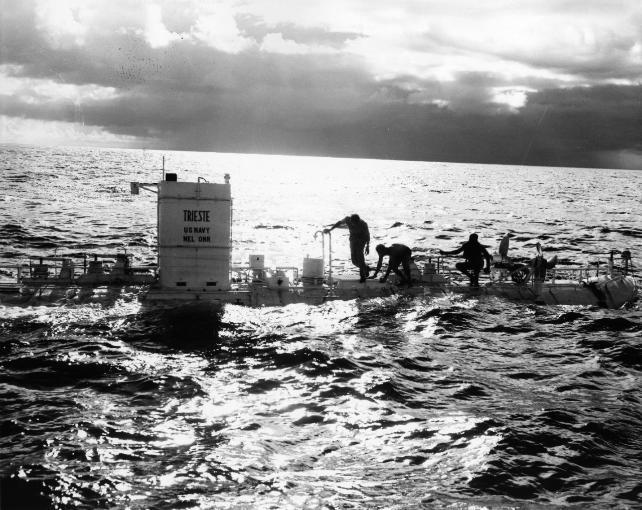 Jacques Piccard, Guiseppe Buono, and Ernest Vigil inspecting the Bathyscaphe Trieste after the first dive off the coast of Guam.
