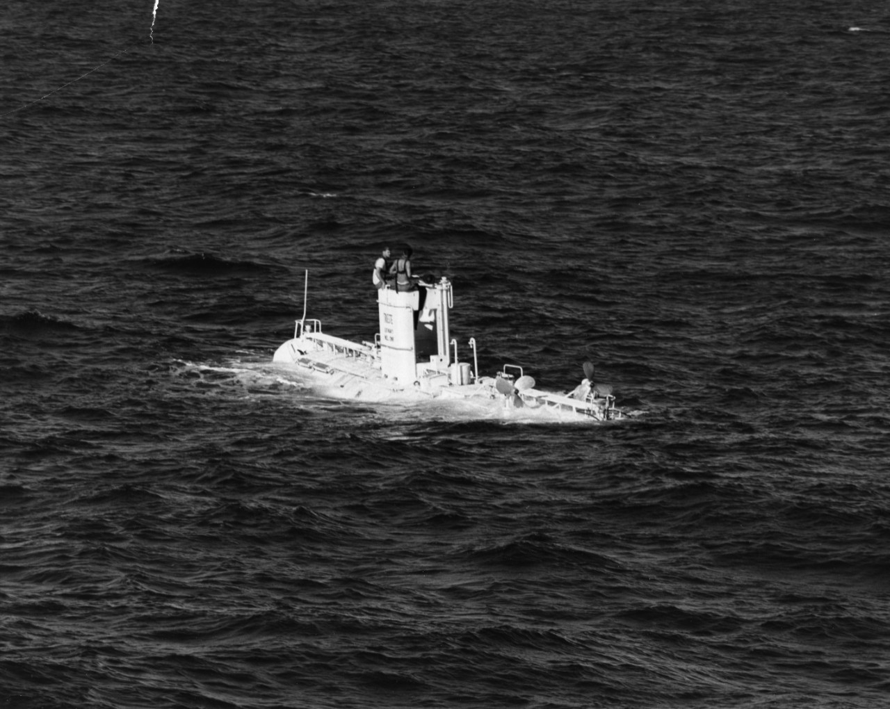 Bathyscaphe Trieste after her dive at 18,600 feet. On the conning tower are Dr. Andrea B. Rechnitzer (left) and Jacques Piccard, the two men who were at the controls.