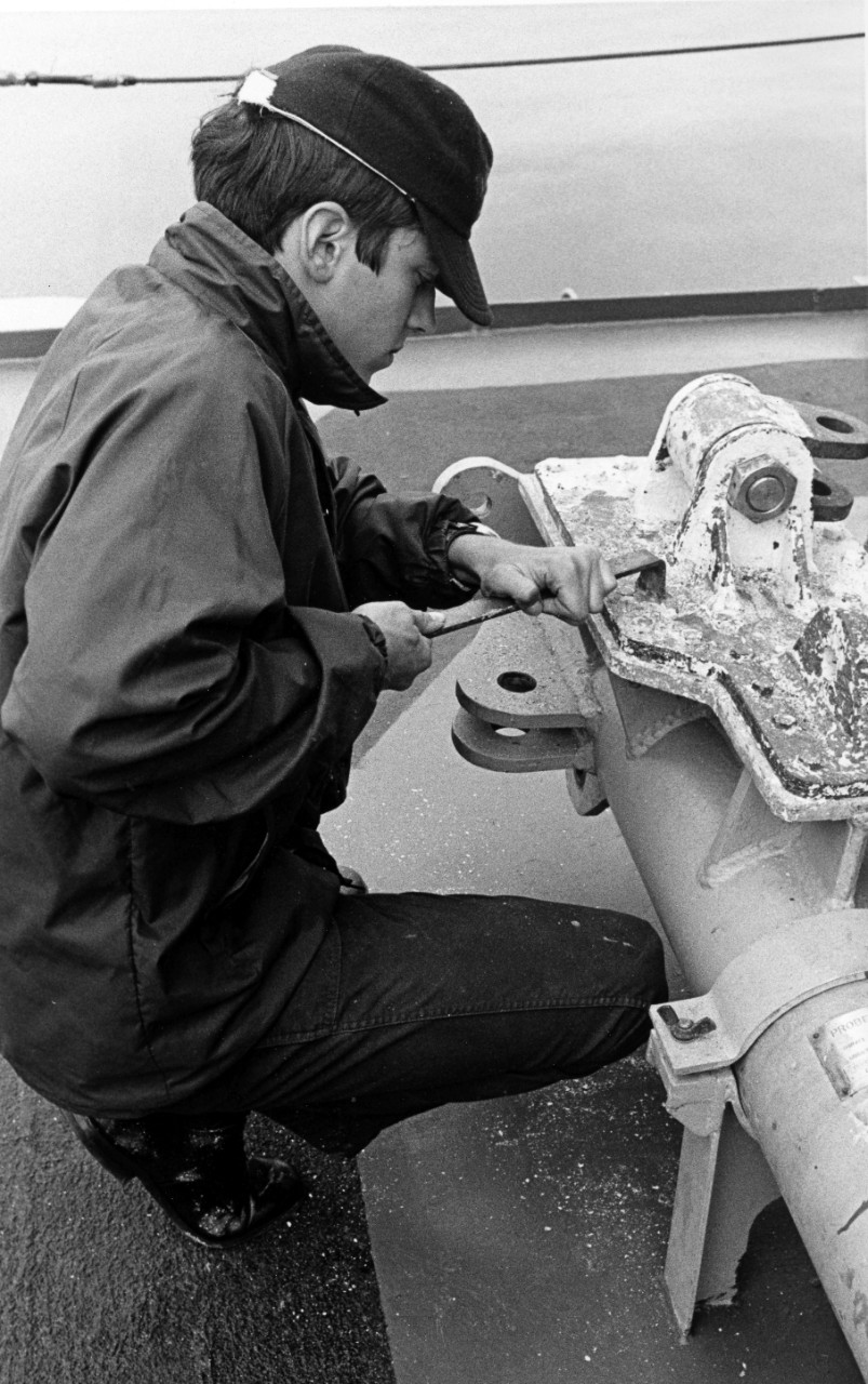 Pacific Ocean - seaman apprentice Bruce A. Brown chips paint on the fantail of the destroyer USS Hull DD-945. September 17, 1975.
