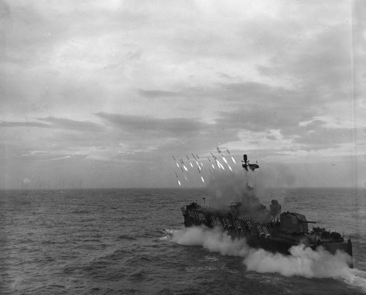 Leaping from their launchers like racehorses from the starter's barrier, a salvo of rockets heads towards a distant target as a Navy LSM(R) (Landing Ship Medium (Rocket)) undergoes drills. Light and mobile, but packing a terrific punch, rockets have played a major role in World War II.