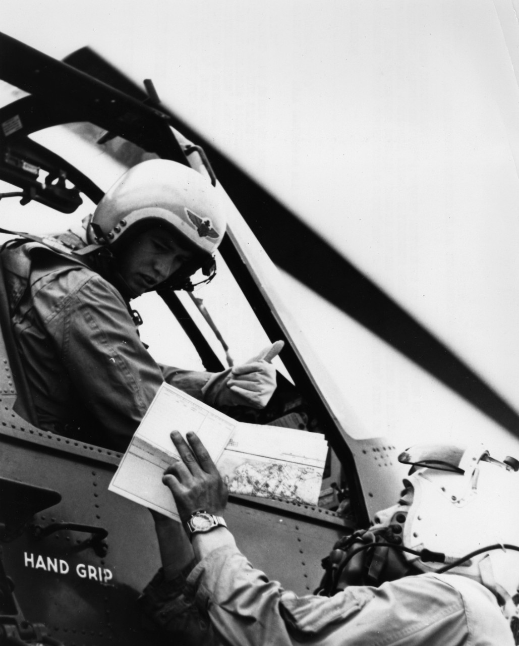 Lieutenant Junior Grade Joseph Greer, pilot of a U.S. Navy helicopter from the aircraft carrier USS Kearsarge (CV-33), receives briefing information from a Japanese pilot. Helicopters were used to carry food, clothing, medical supplies, and other necessities to victims isolated by floods from Typhoon Vera.</p>