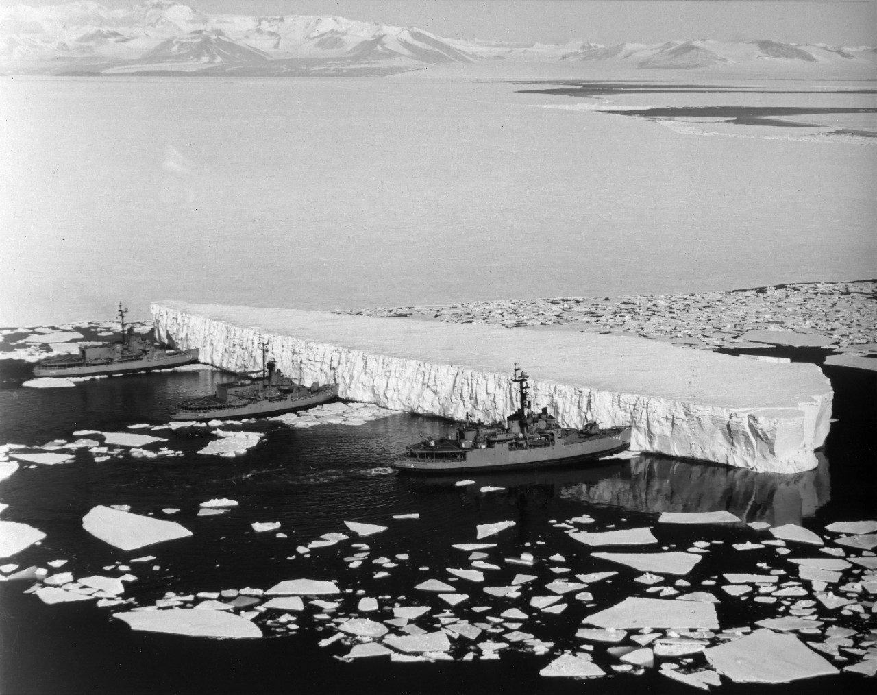 U.S. Navy Icebreakers (L-R) USS Burton Island (AGB-1), USS Atka (AGB-3), and USS Glacier (AGB-4) push together to move a huge iceberg from the channel to McMurdo Station, Antarctica.