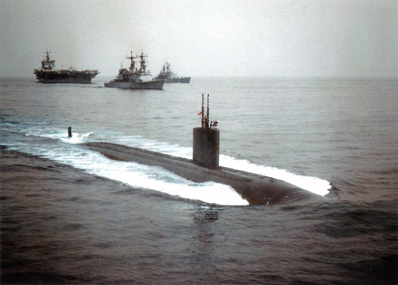 The US Navy's nuclear powered Los Angeles class fast attack submarine, USS Jefferson City (SSN-759) (bottom) leads the pack during joint navigational maneuvers with the aircraft carrier USS Enterprise (CVN-65) (top left), the Spruance class destroyer USS Hewitt (DD-966) (top center), and the nuclear powered cruiser USS California (CGN-36) (top right), during operations in the Arabian Gulf. Enterprise arrived in the gulf to join forces with the aircraft carrier USS Carl Vinson (CVN-70) and her task group, in support of Operation Southern Watch and the extended no-fly zone.