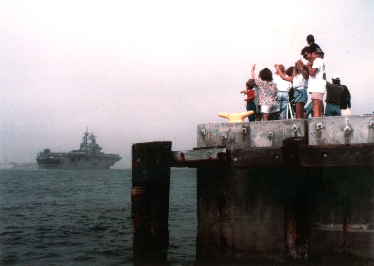 Families wave goodbye as the U.S. Navy's amphibious assault ship USS Essex (LHD-2) departs Naval Station San Diego. Essex departed on 10 October 1996 for  a six month deployment in the Western Pacific. 
