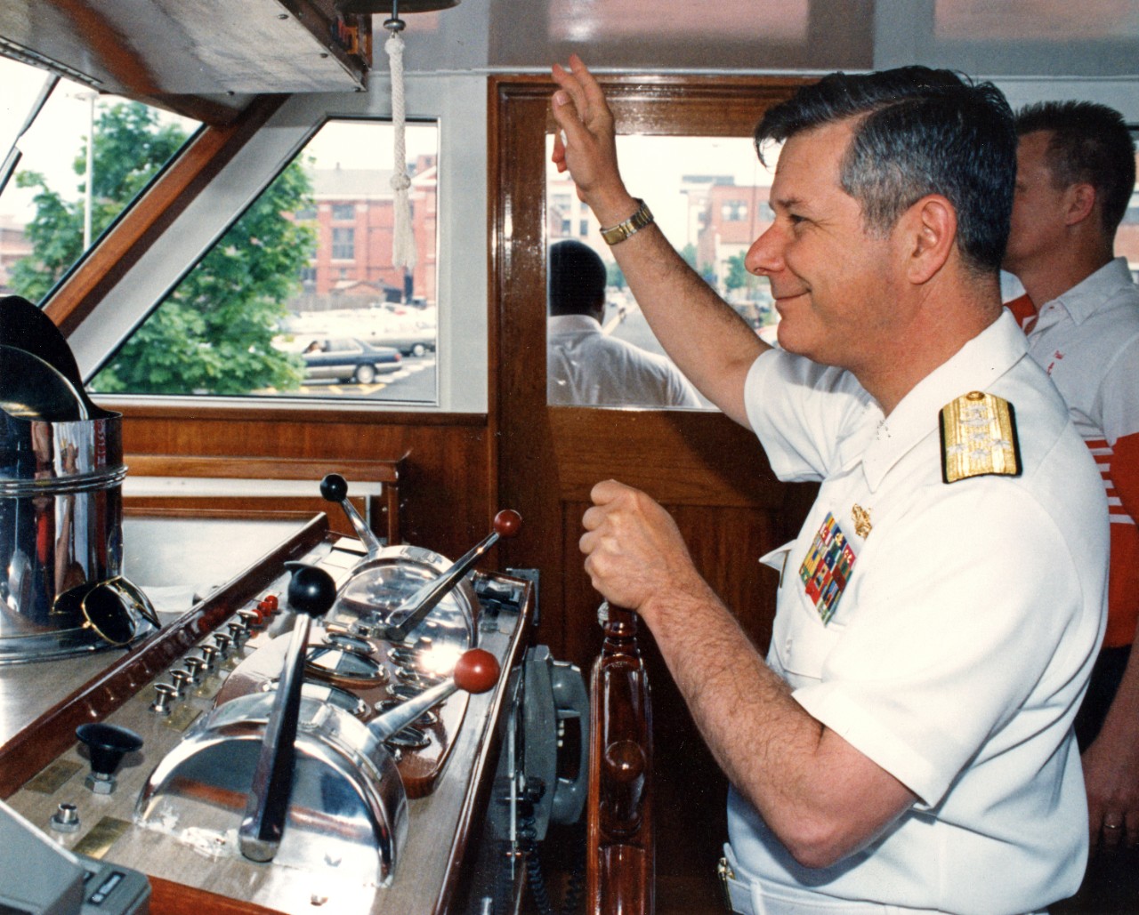 Chief of Naval Operations, Admiral Jeremy "Mike" Boorda, at the helm of the CNO barge Chesapeake, off the Washington Navy Yard.