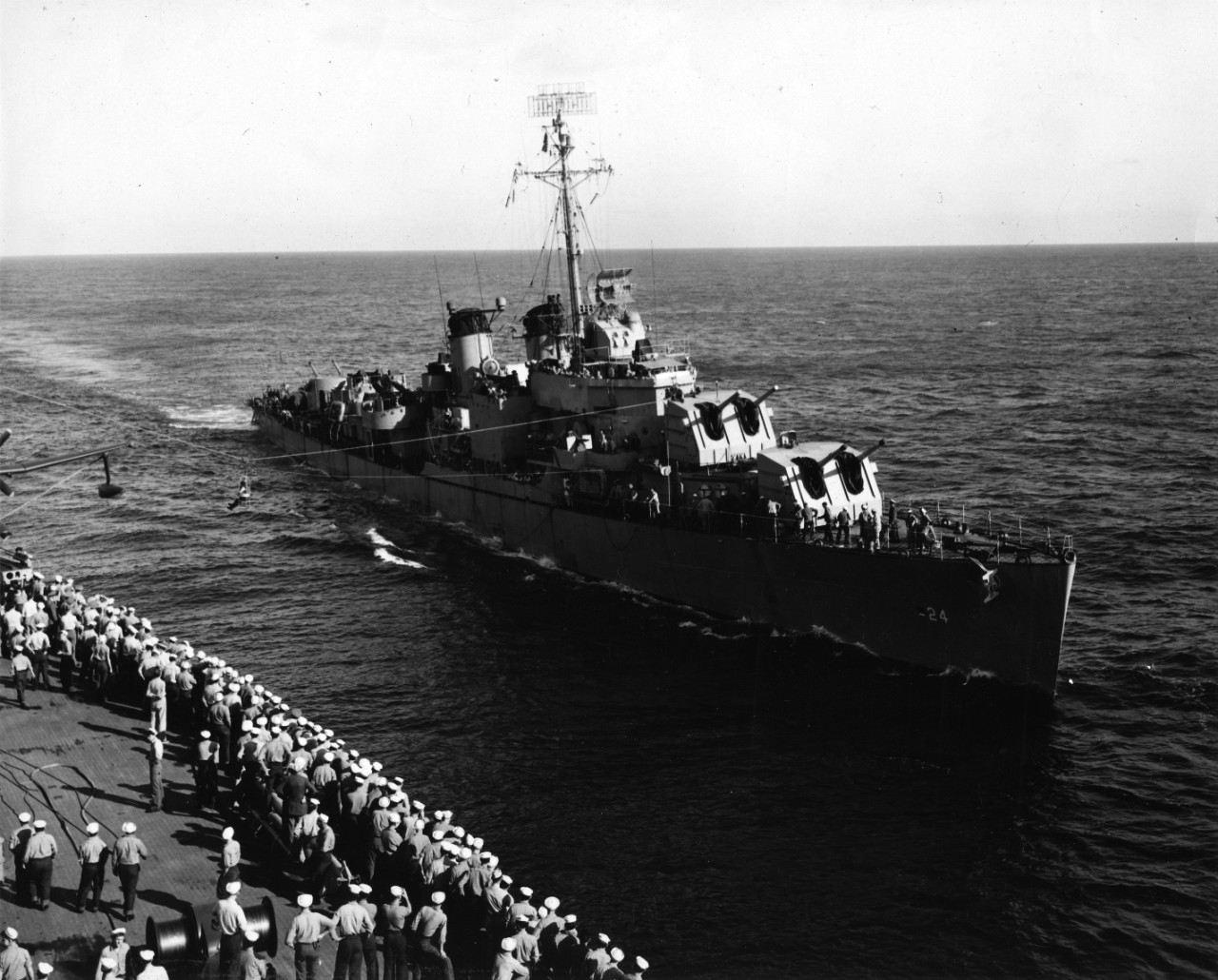 The transfer of personnel by high line from the battleship USS Wisconsin (BB-64) to the destroyer mine layer USS Thomas E. Fraser (DM-24) attracts a large crowd of spectators from the mixed crew of Reserves and Regulars on board Wisconsin. Photo taken during the two week Naval Reserve training cruise to Cristobal Canal Zone.