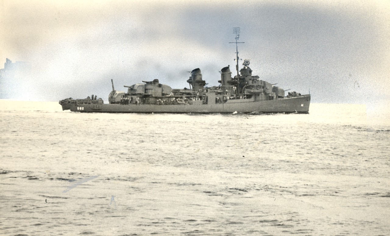 USS Conner (DD-582) underway. Note that the background, which appears to have been a city skyline, has been replaced with a mock blue-tinted sky. This process has also slightly altered the silhouette of the ship.