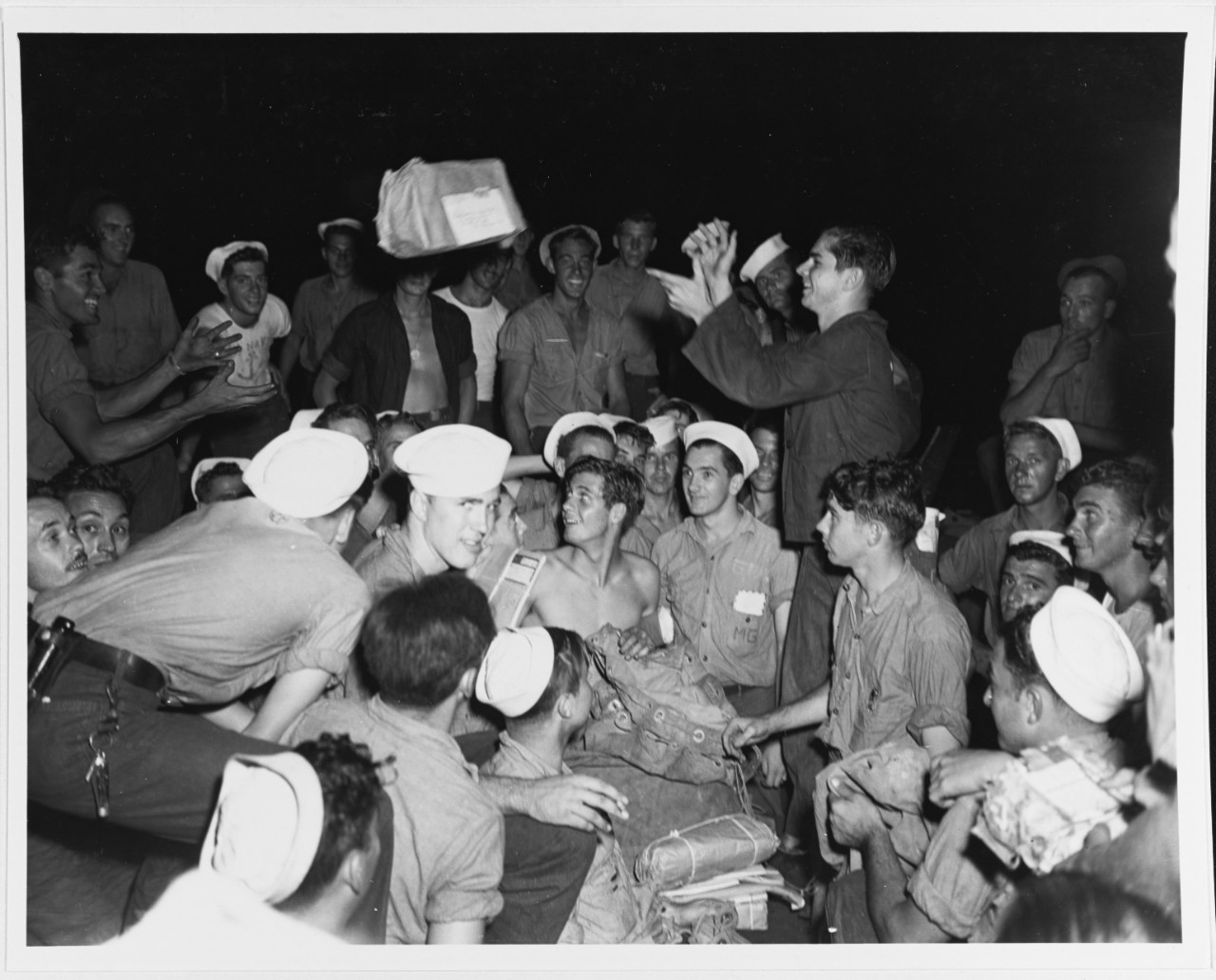 USS Halford (DD-480), distributing mail, in Tulagi Harbor, Solomons, 22 May 1944. William Couvillia, RDM3c is tossing the package.