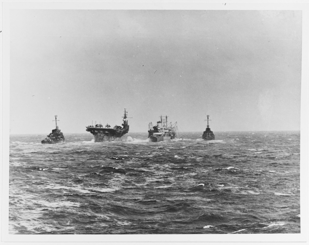 USS Langley (CVL-27) refueling at sea, 13 November 1944, during Philippines campaign. A destroyer approaches her stern to deliver mail.