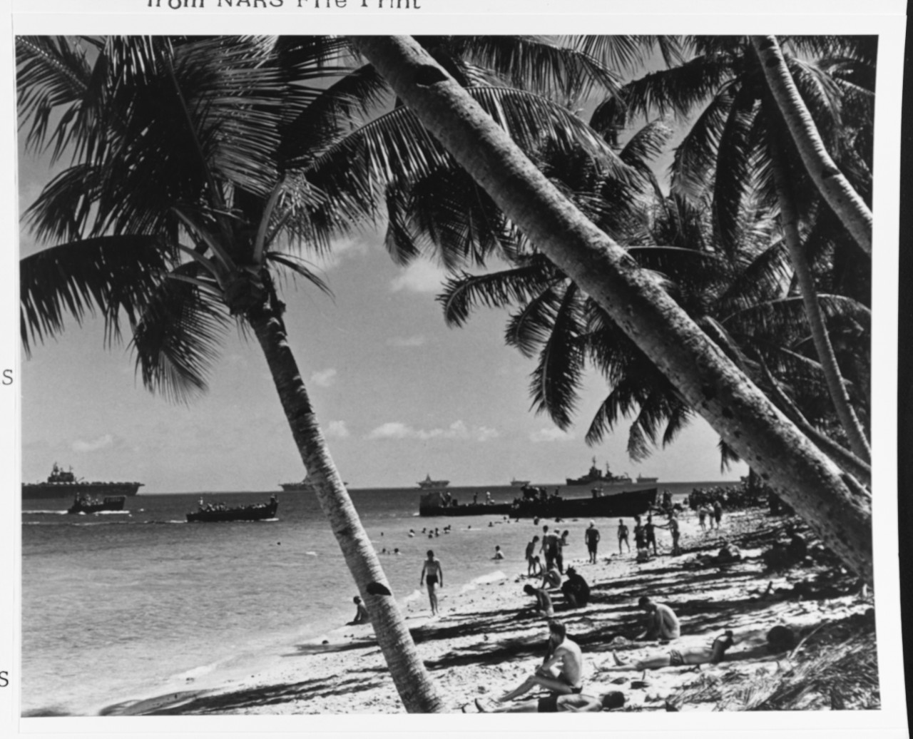 Men swimming at the fleet recreation area, as landing craft bring other sailors ashore for liberty, circa May 1944, as the fleet prepares for the Marianas Campaign. Carrier at left is USS Enterprise (CV-6).