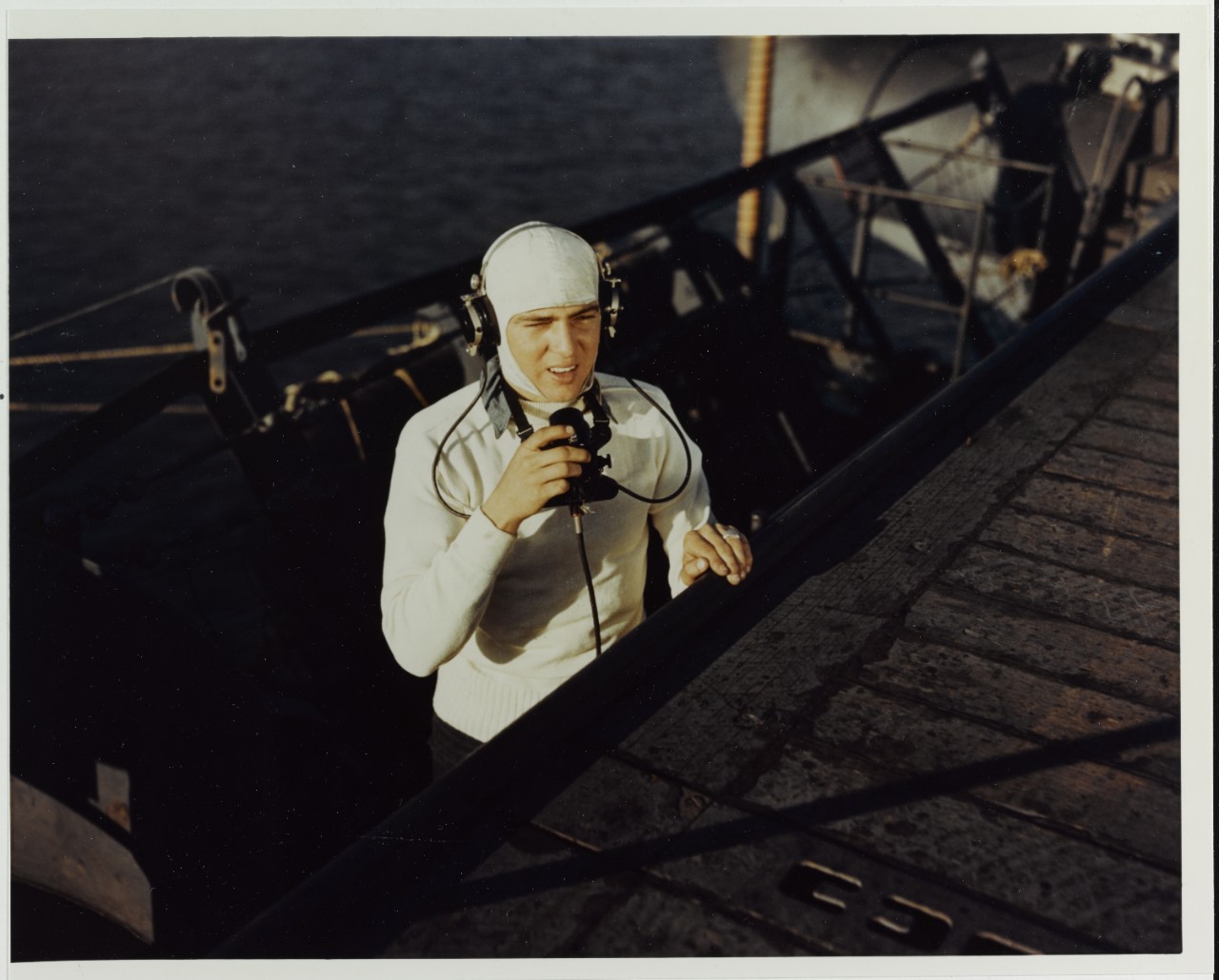 Flight Deck "Talker" mans his station in the catwalk of a training escort carrier, circa 1943-1945