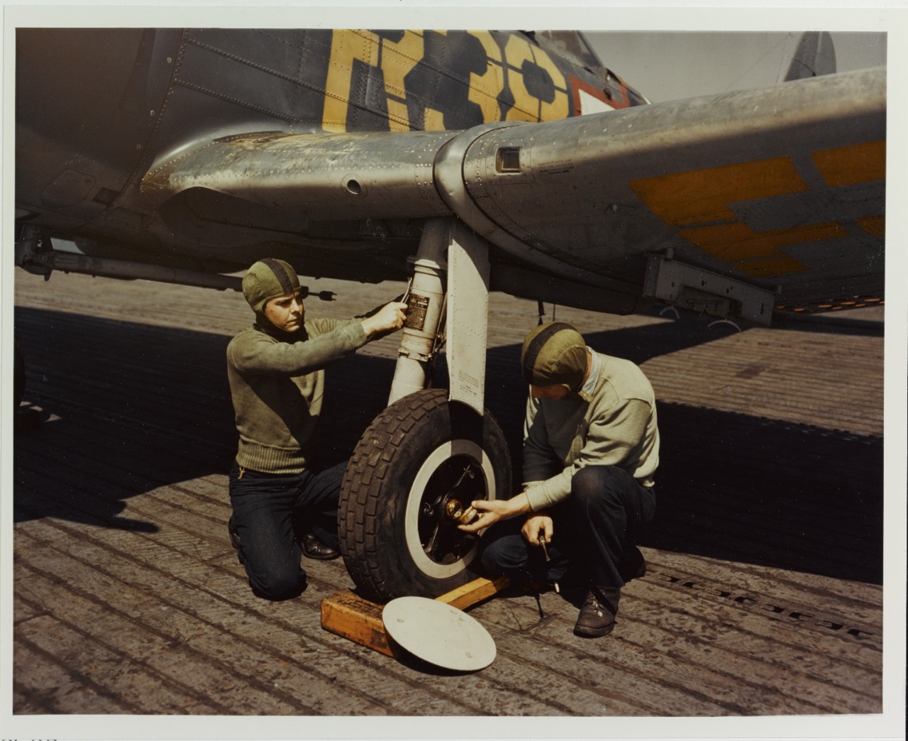Plane Inspectors check landing gear, circa 1943
