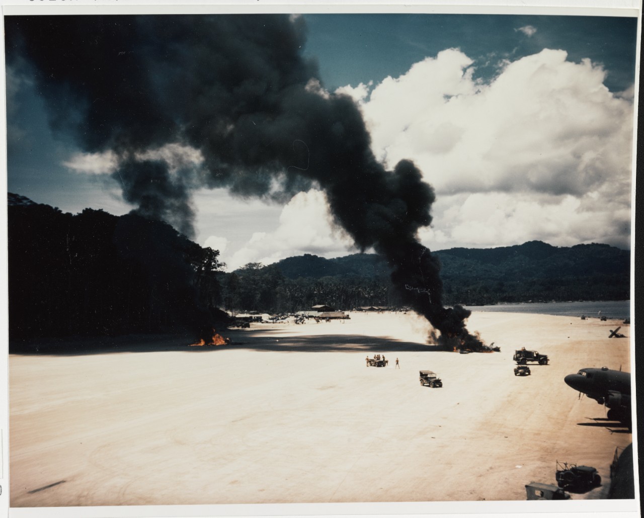 Accident at Vella. Two planes' wreckage burns on the airfield, after a collision, circa 1943-1944
