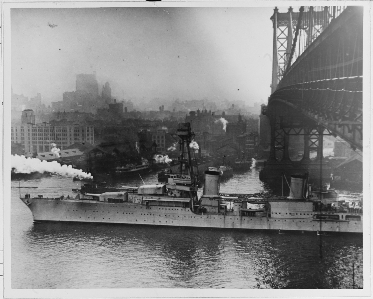 USS NORTHHAMPTON (CA-26) (1930-1942) stands down the East River under Manhattan Bridge. 