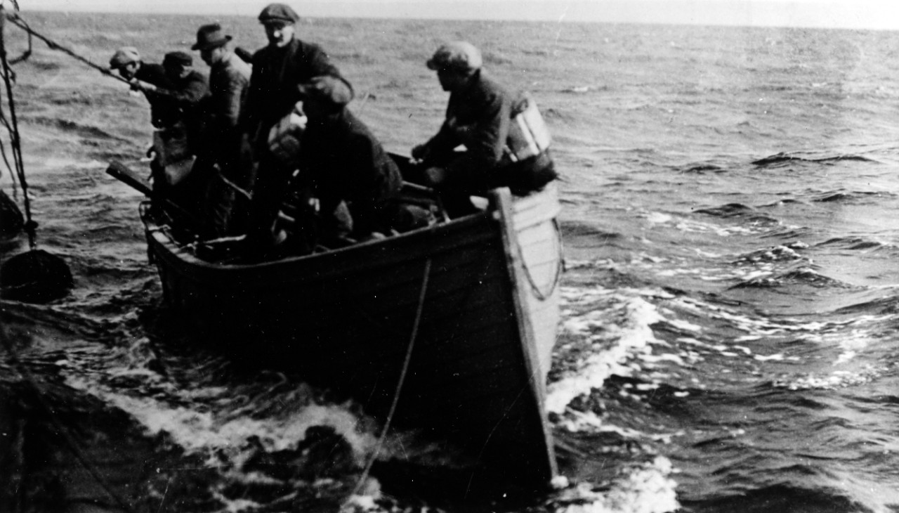 Merchant Ship crewmen bring their lifeboat alongside another ship, after an incident in the Eastern Atlantic, circa 1918