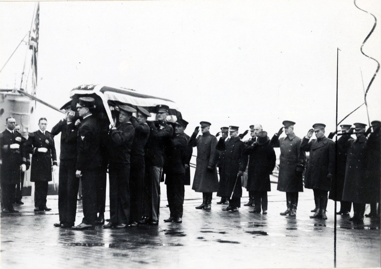 <p>A detail of Marines and sailors lift the body of the unknown soldier as the funeral party disembarks USS Olympia (CL-15) at Washington, DC after its trip from Le Harve, France. Original image is from the collections of the Marine Corps, #521811.</p>