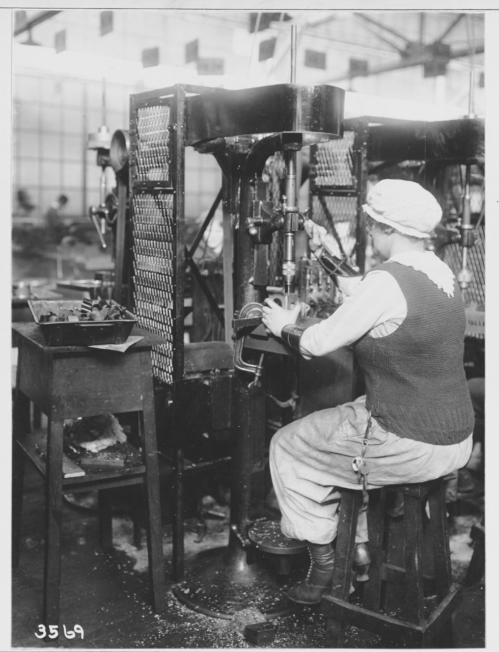 Women workers running drill press