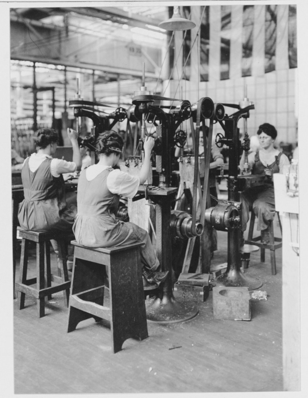 Women workers running drill presses