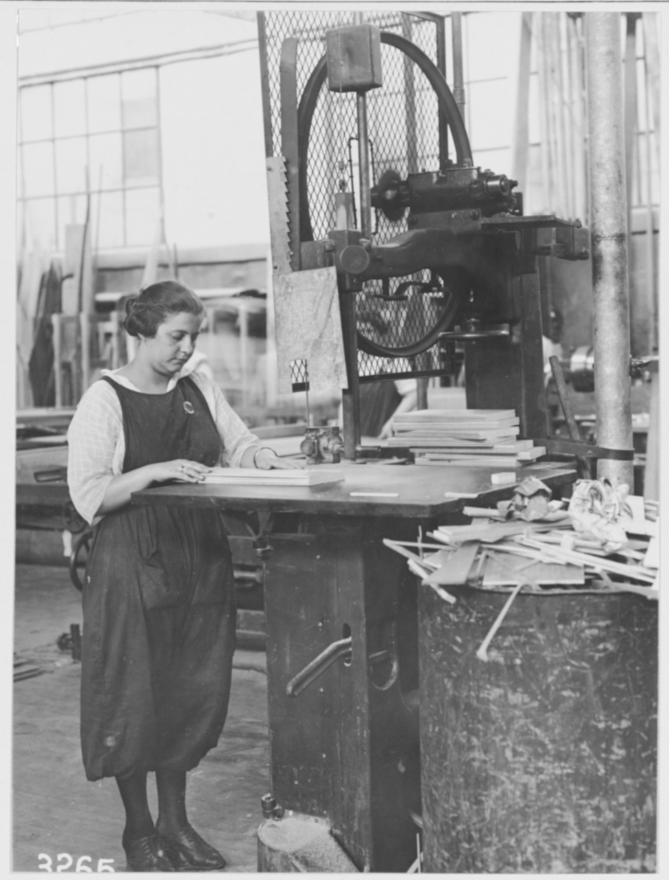 Woman worker operating band saw