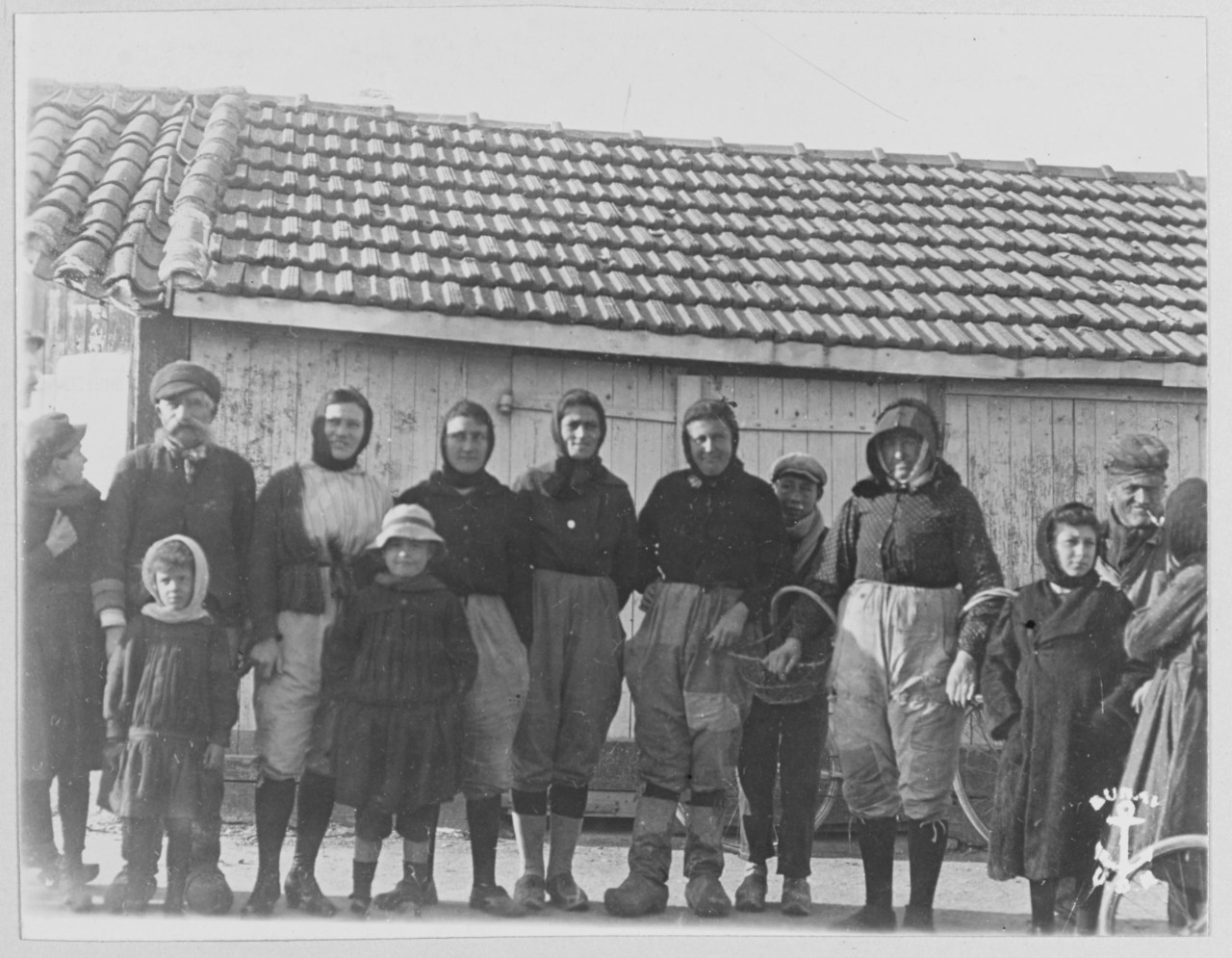 France. Finistere-Fisher Fold. Villagers, adults and children stand in a row, pose in front of building