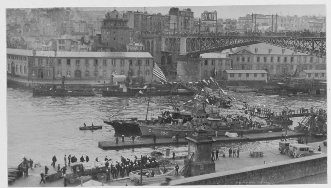 Ships flying American flag by bridge in Brest, France during World War I.