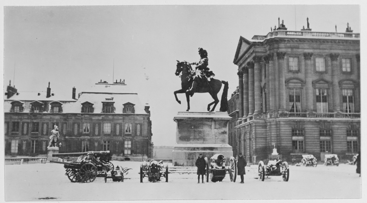 Statue of man on horseback and artillery wagons in snow, Paris, France during World War I.