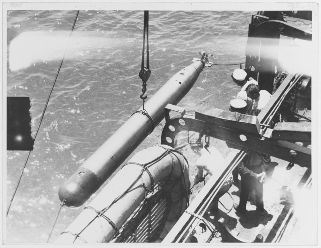 Hoisting torpedo aboard a destroyer after a run. ONI, 1936