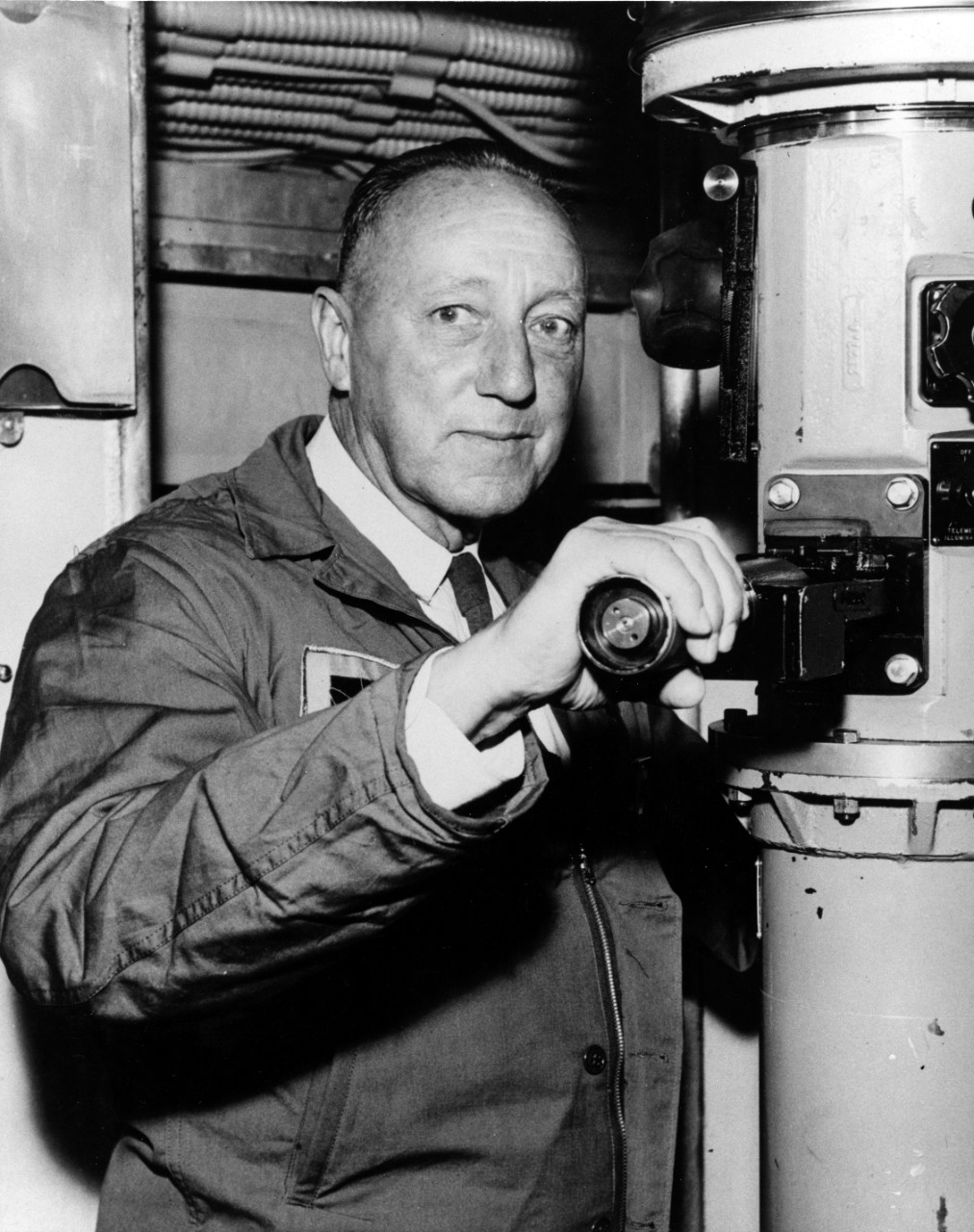 VADM Charles A. Lockwood, USN (Ret.) is shown at the periscope of the submarine off San Francisco, 24 June 1957. FADM Chester W. Nimitz  and other submarine admirals were also onboard, taking their first cruise on a nuclear submarine. 