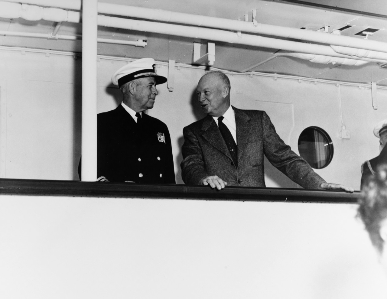 President Dwight D. Eisenhower and Vice Admiral C. Turner Joy, Superintendent of the US Naval Academy, pose for photographers on the deck of USS Williamsburg, at the Santee Dock at the Academy