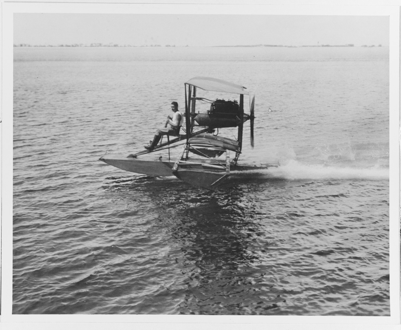 Lieutenant Earl W. Spencer underway in the "Skimmer " taxing trainer, June 1916. This appears to be a Curtiss "A" type aircraft with the tall and most of the wing removed.