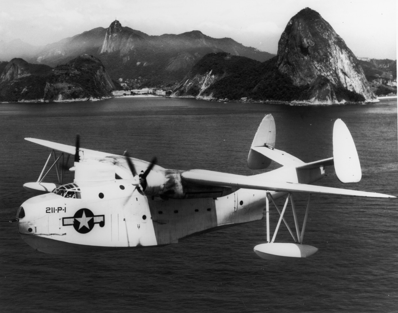 Martin PBM-3 Mariner Patrol Bomber in flight over Rio de Janeiro, Brazil, December 1943. Sugarloaf Mountain is in the background. Plane appears to be from VP-211. NARA photo number 80-G-56973.