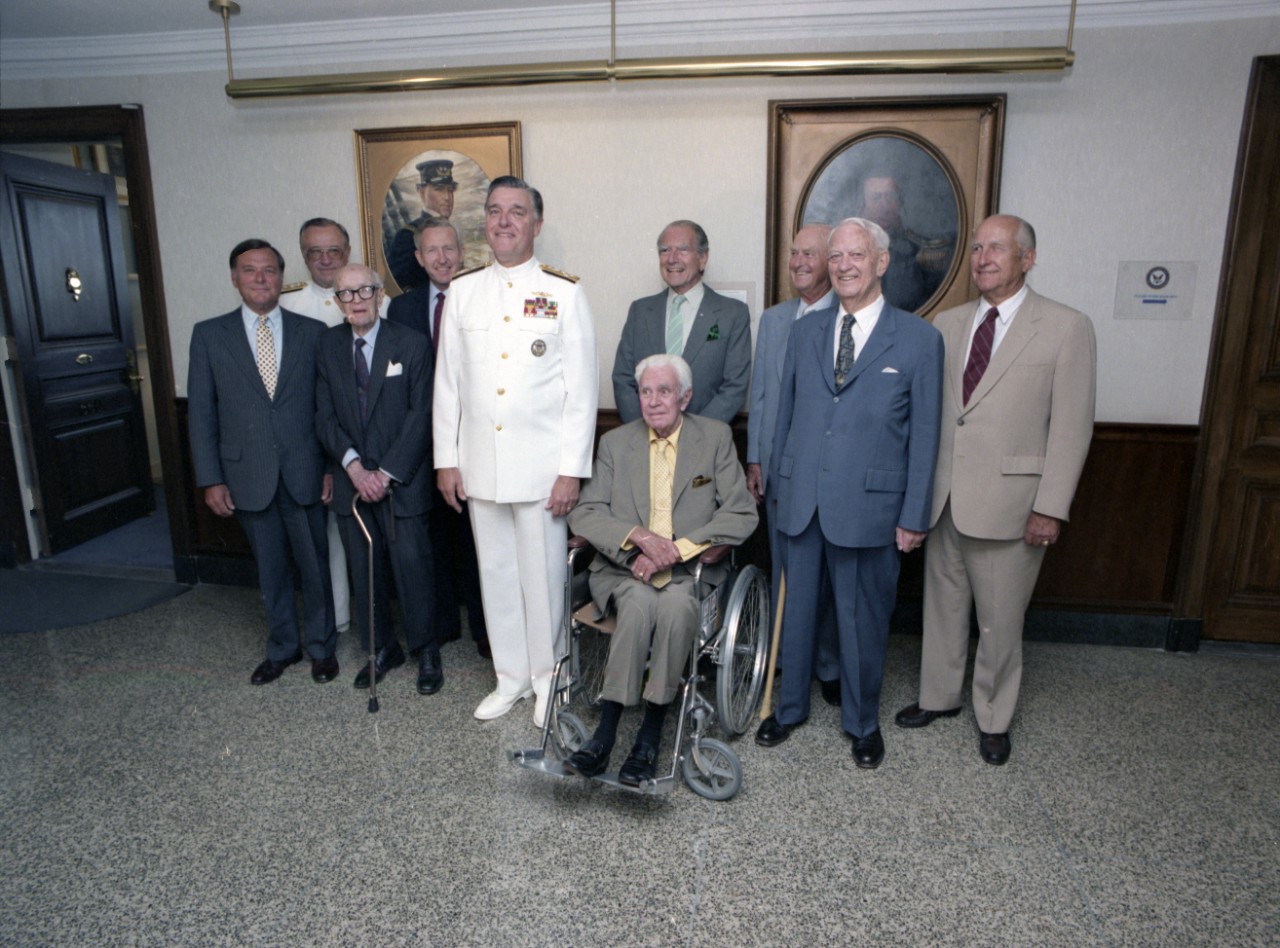 Current and past Chiefs of Naval Operations (CNO) gathered in the Pentagon Office of the Chief of Naval Operations for the unveiling of the CNO portraits, 26 June 1986. Present are (from left to right): Admiral James L. Holloway III, USN (Retired); Admiral Carlisle A.H. Trost, USN, CNO Designate; Admiral Robert B. Carney, USN (Retired); Admiral Thomas B. Hayward, USN (Retired); Admiral James D. Watkins, USN, current CNO; Admiral George W. Anderson, USN (Retired), seated; Admiral Elmo R. Zumwalt, Jr., USN (Retired); Admiral David L. McDonald, USN (Retired); Admiral Arleigh A. Burke, USN (Retired); and Admiral Thomas H. Moorer, USN (Retired).  Official U.S. Navy Photograph, from the collections of the Naval History and Heritage Command.