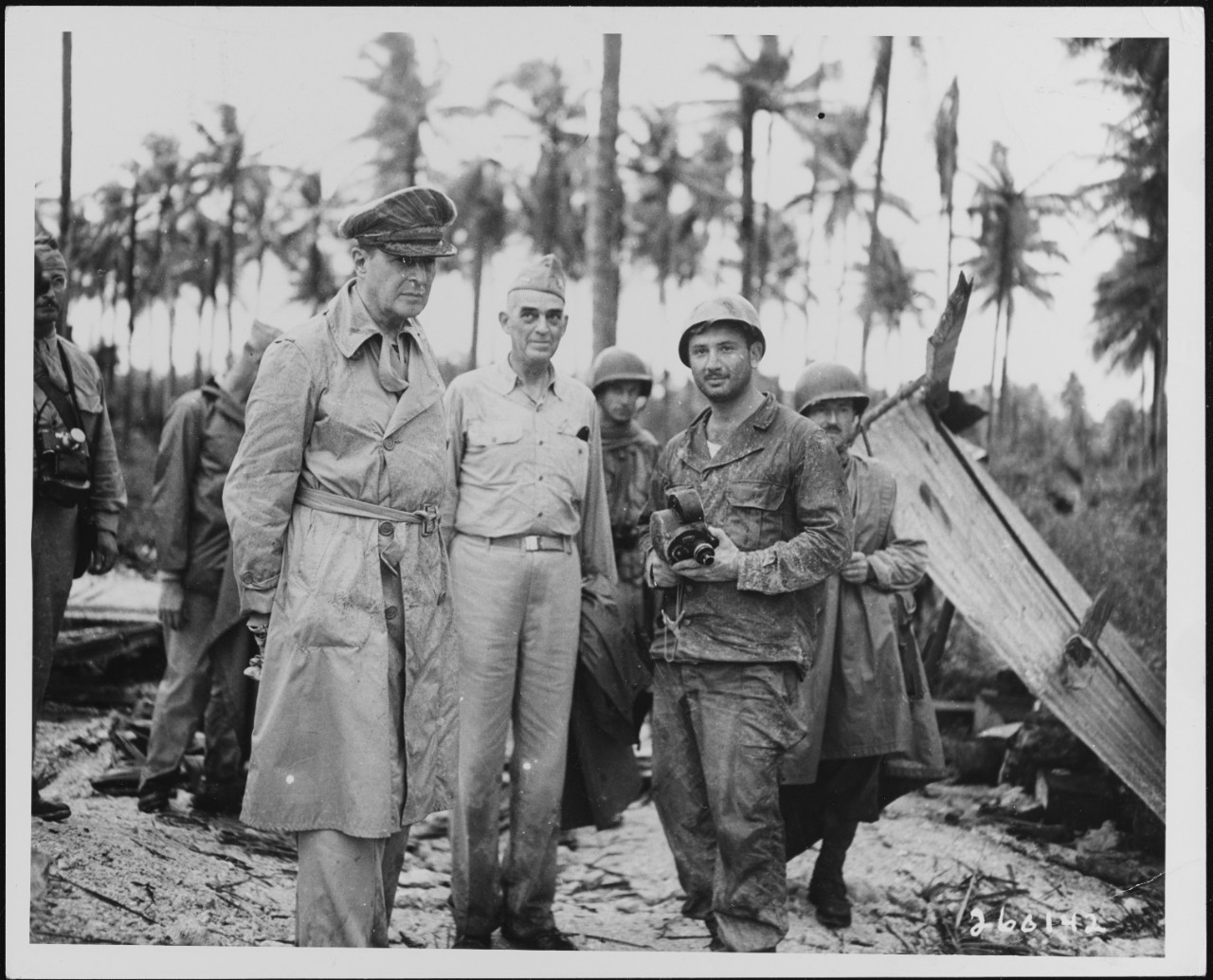 General Douglas MacArthur, Vice Admiral Thomas Kinkaid, and T/Sgt Daniel Rocklin examine dome damaged by naval bombardment, February 29, 1944