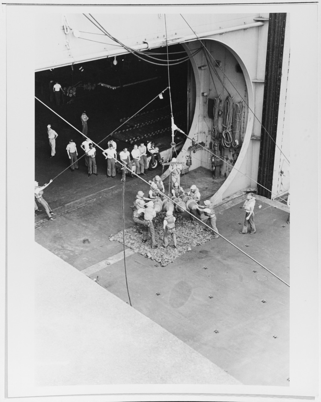 Four bombs are lowered to the deck of the USS RANGER (CVA-61)