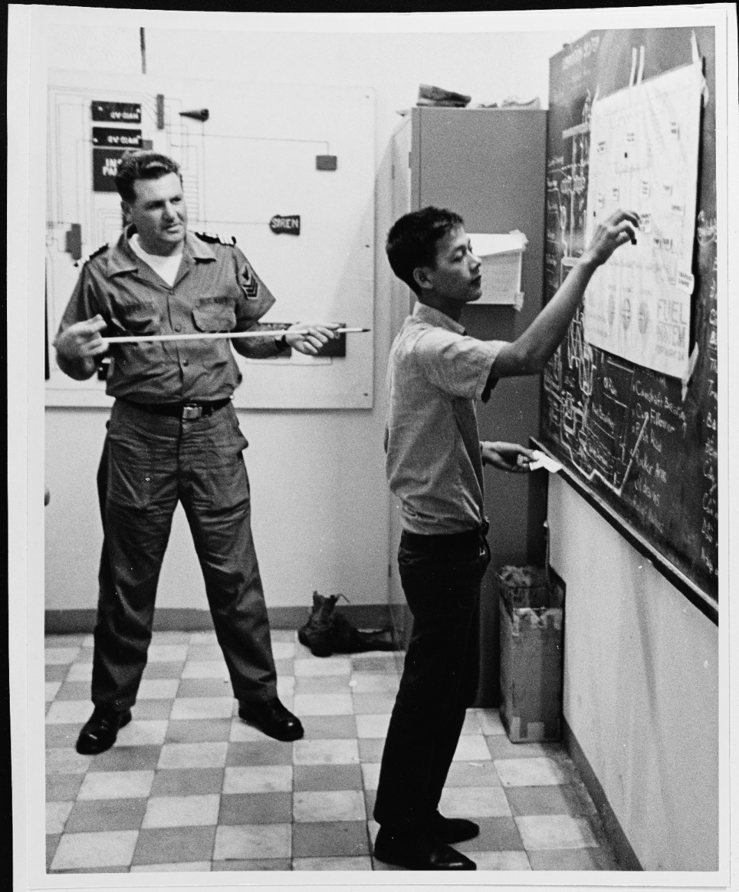 An instructor at the small boat school discusses nomenclature with a student at Saigon. Photo taken in December 1969.