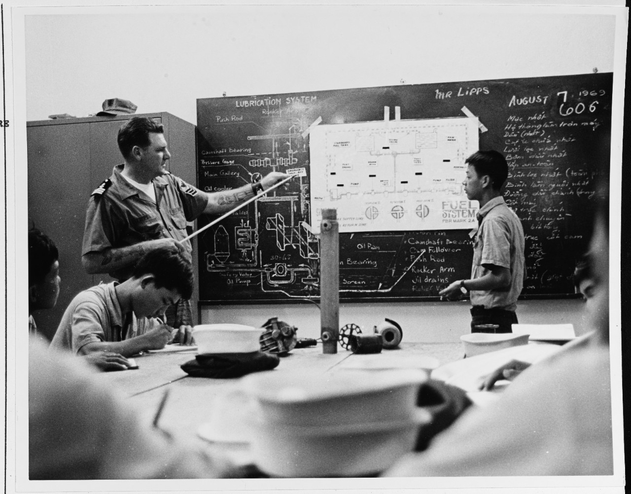 An instructor discusses nomenclature with a student at the small boat school, Saigon. Photo taken in December 1969.