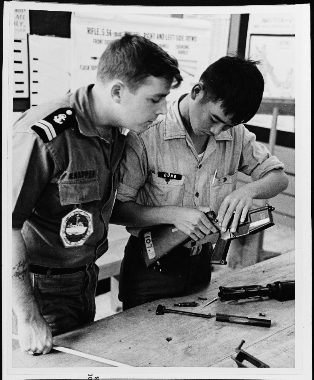An instructor watches closely as a Vietnamese Student assembles a M-16 rifle
