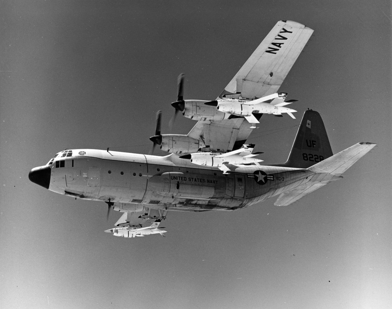 Point Mugu, CA - a Fleet Composite Squadron 3 (VC-3) DC-130A Hercules Cargo Transport aircraft in flight over the target range. The aircraft is armed with three BQM-34 Firebee target drones. August 1975. 
