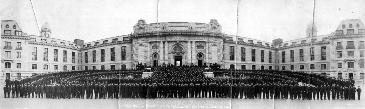 Panoramic image of a large group of midshipmen posing in front of Bancroft Hall at the U.S. Naval Academy, Annapolis, MD, in December 1920. From the RADM Bradford Bartlett Collection.