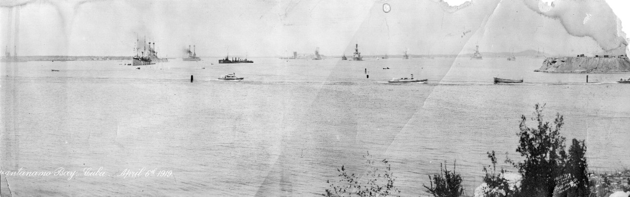 General view of the Atlantic Fleet at Guantanamo Bay, Cuba, April 6, 1919. Ships in the bay include: USS Perkins (DD-26), USS Henley (DD-39), & USS Walke (DD-34). The image has been torn into two pieces and digitized in parts (this is the left). This same image can also be found under catalog number UA 571.62.