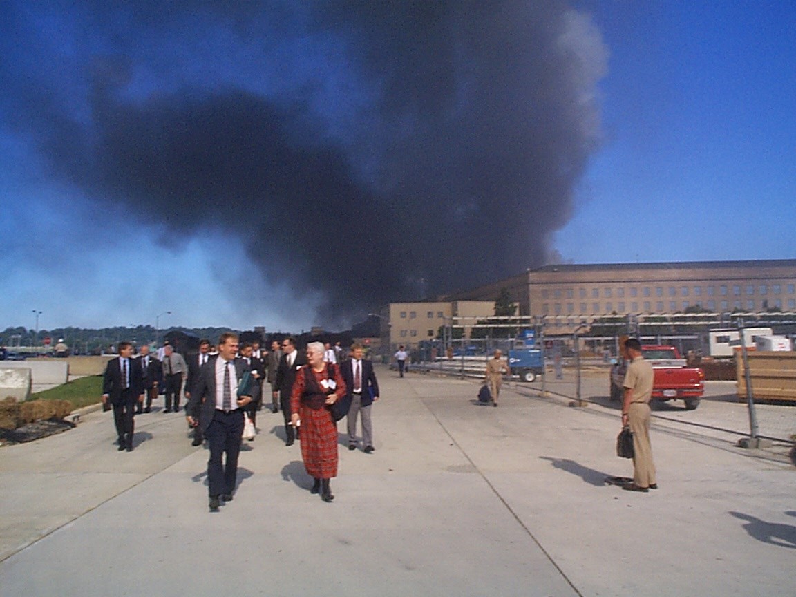 A crowd of people, including members of the Crane Group evacuate the Pentagon following the impact on 11 September 2001