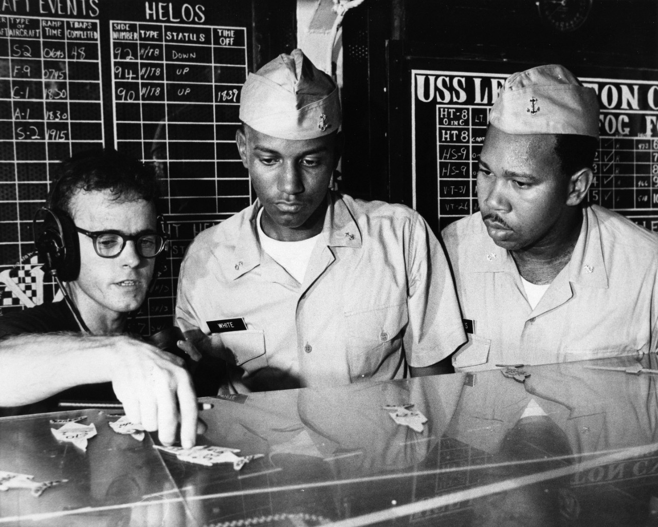 Naval Airman Daniel R. Highfill (left) explains flight deck operations to Midshipmen Charles E. White (center) and Robert E. Williams (right) aboard the aircraft carrier USS Lexington (CVS-16) in the Gulf of Mexico. The midshipmen were part of a group from Prairie View A & M College who were aboard for two weeks of active duty training.