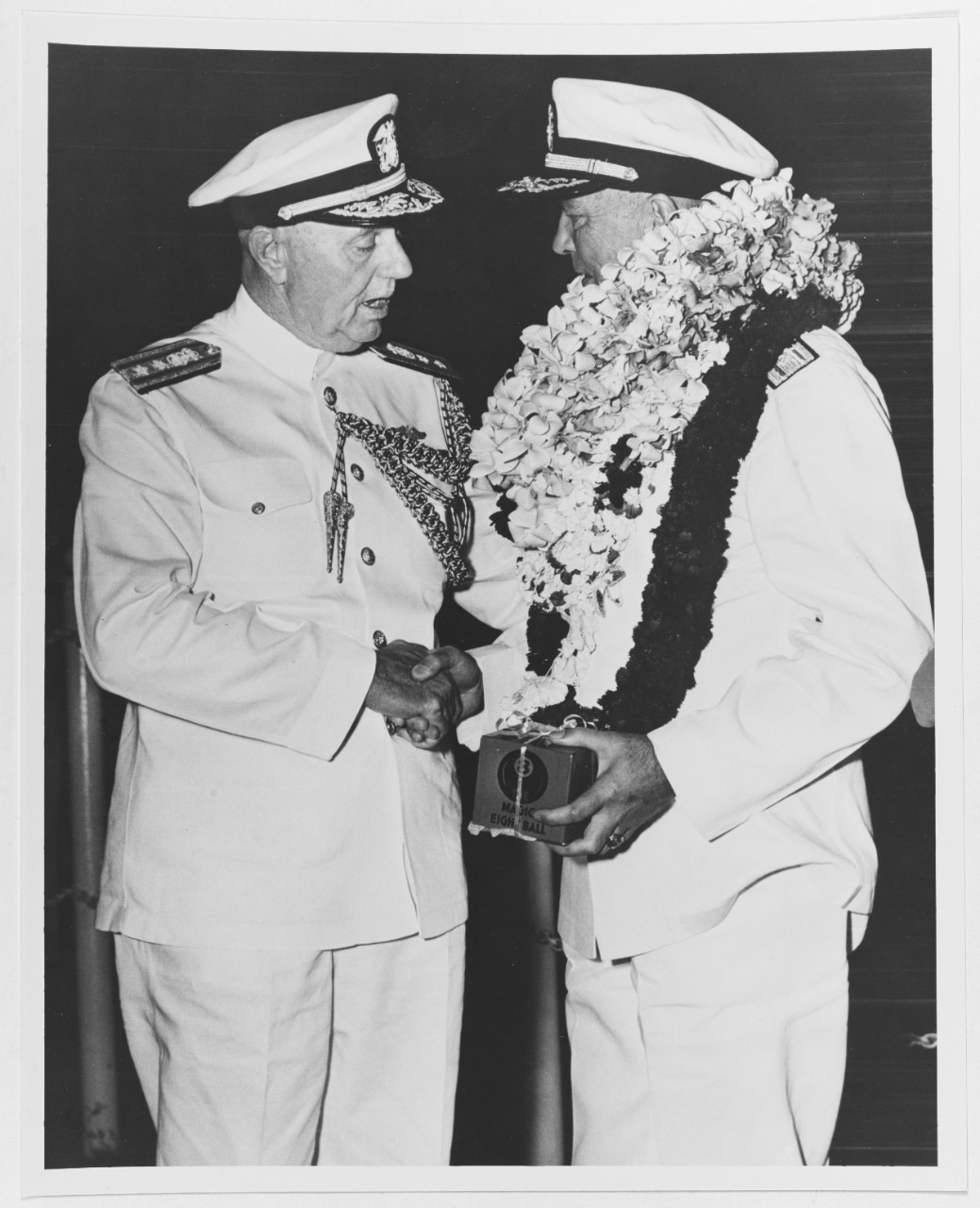 Rear Admiral W.K. Phillips, USN, Commander in Chief, Pacific, Chief of Staff, bids goodbye to Admiral Arthur W. Radford, USN, newly designated Chairman, Joint Chiefs of Staff, 10 July 1953.