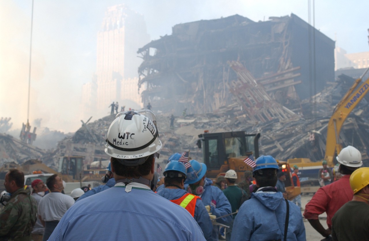 A medic stands among other personnel at Ground Zero in New York City following the attacks on 9/11, 15 September 2001