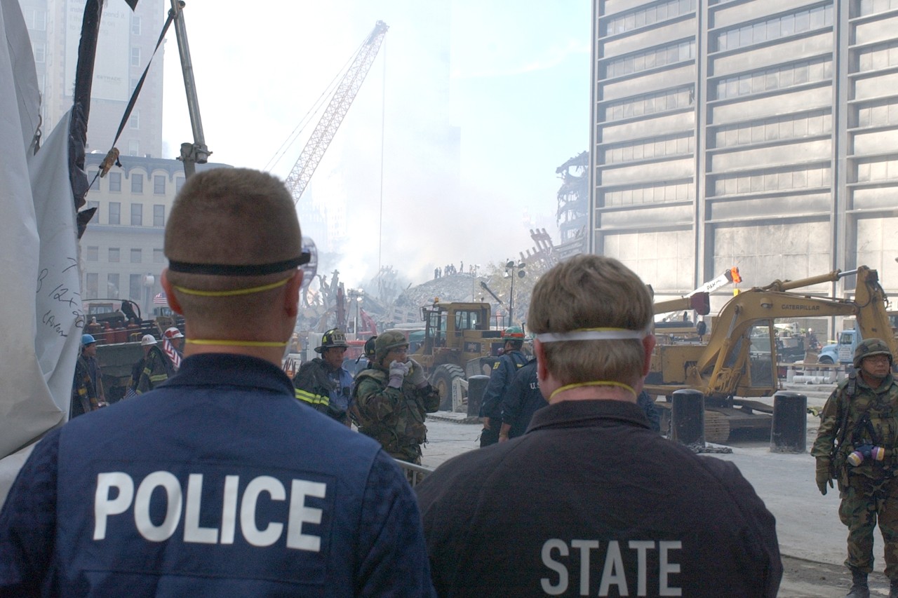 Law enforcement look over the scene at Ground Zero following the attacks on 9/11, 15 September 2001